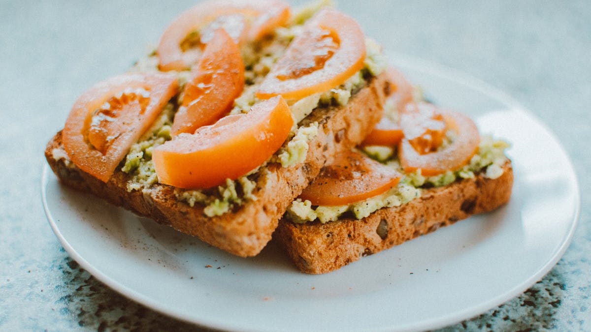 Delicious homemade sandwich with tomato, avocado on wholegrain bread, perfect for a healthy meal.